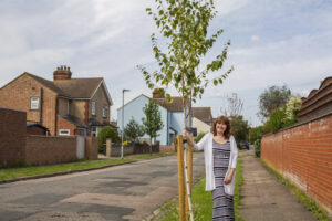 Diana standing next to a newly planted tree