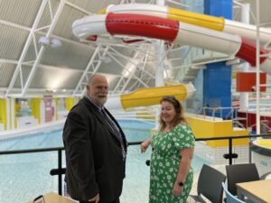 Mayor Tom Wootton and a lady at Oasis Pool showing flumes and the pool.