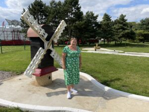 Crazy golf with windmill and lady in front